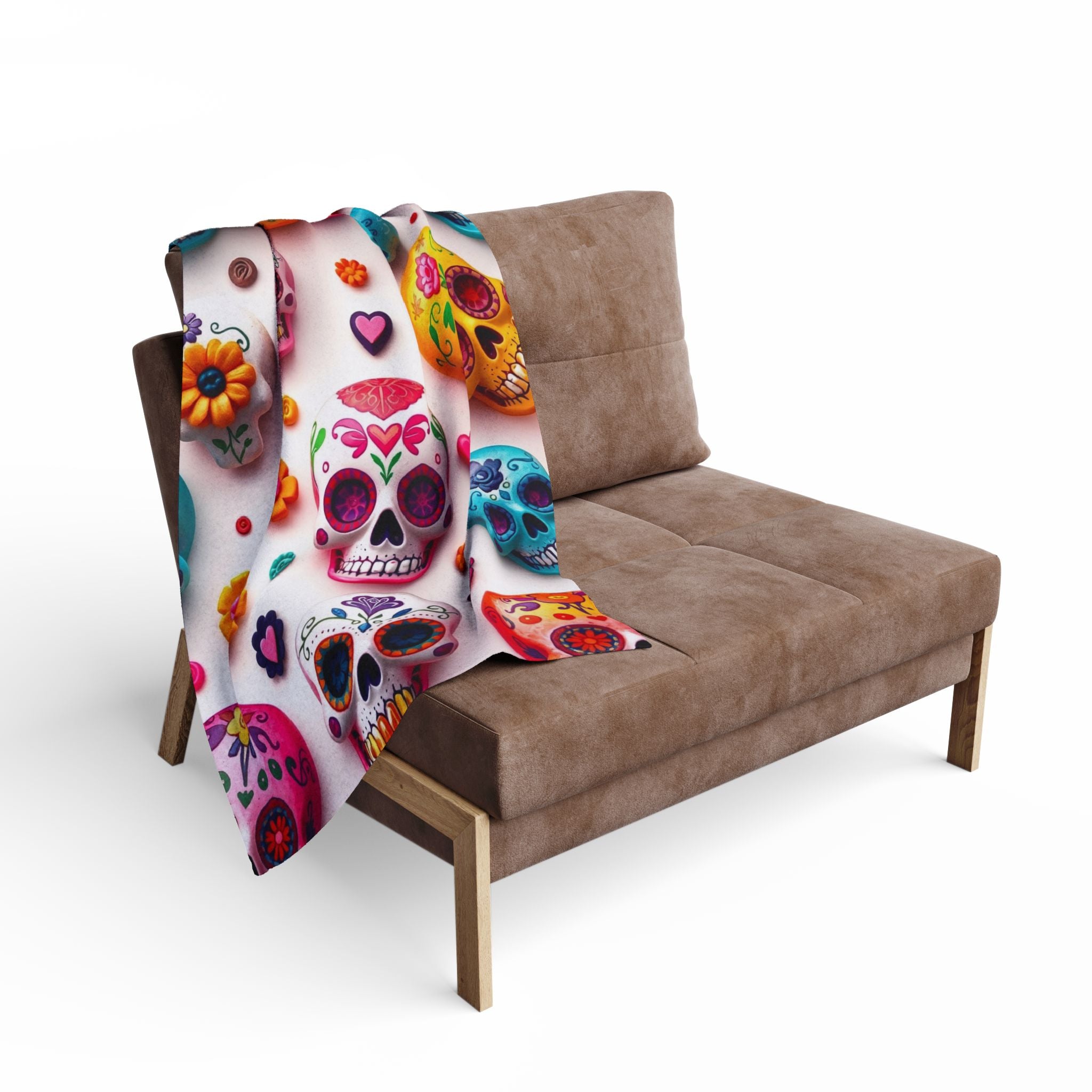 Colorful mexican sugar skull patterned blanket throw draped over a brown sofa on a white background.