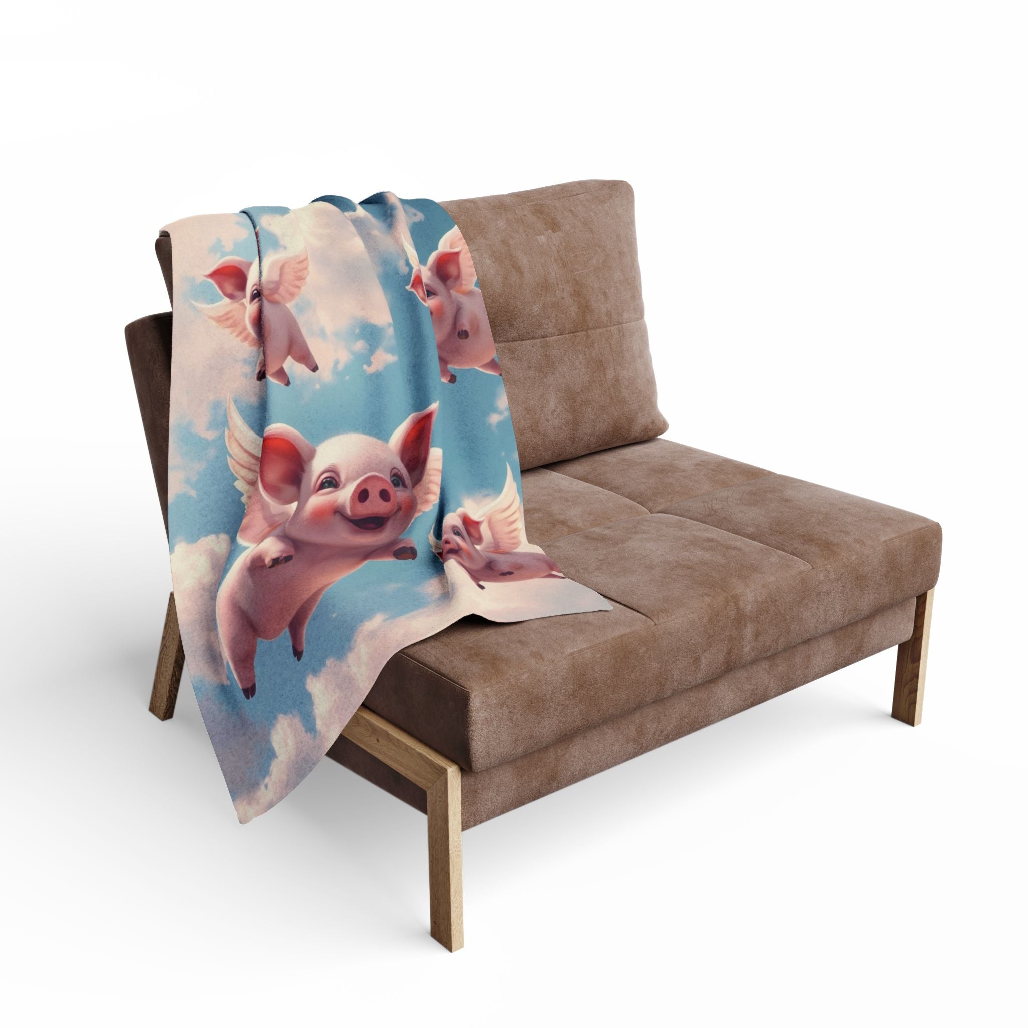 Futon with a cartoon flying pig design blanket draped over it on a white background.