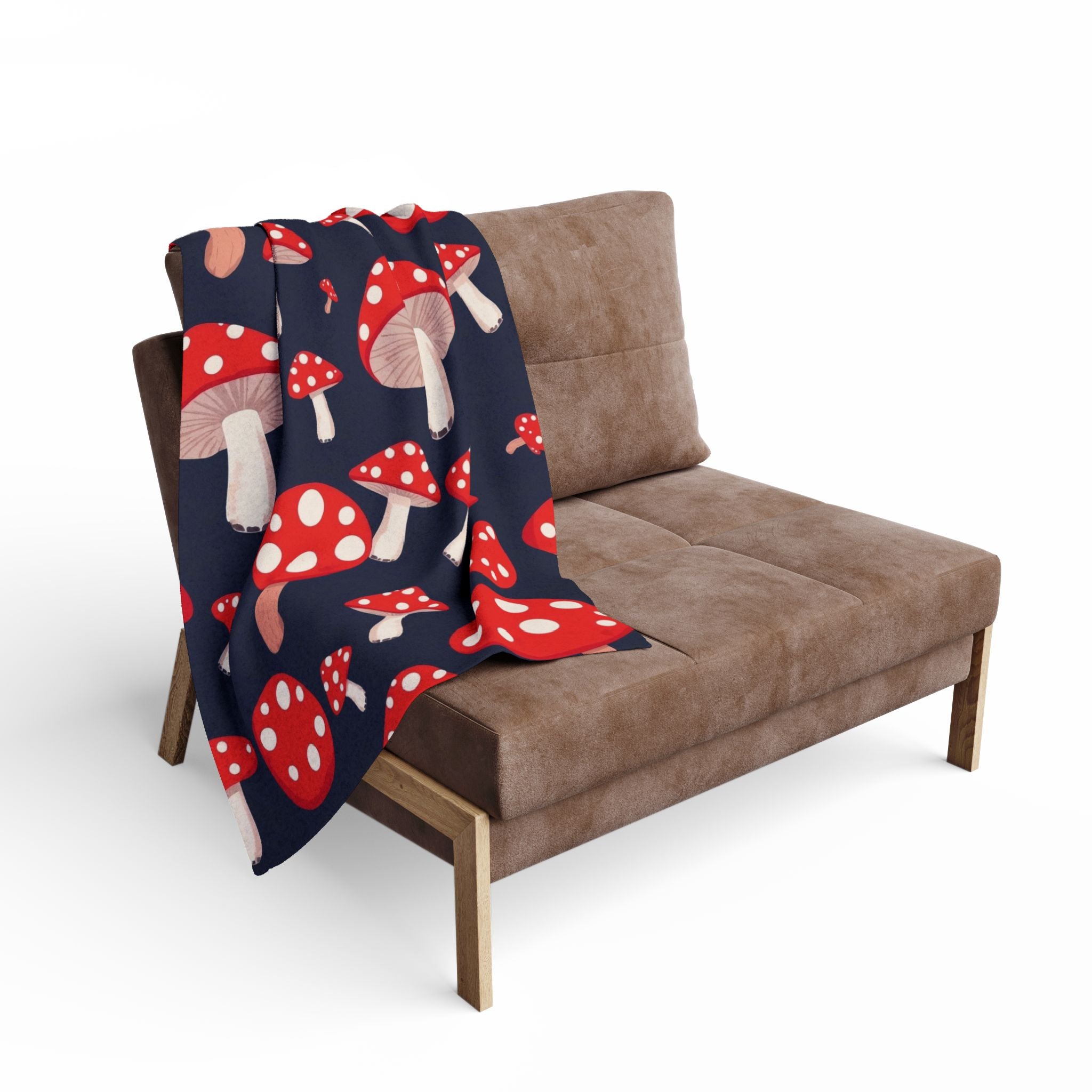 Brown sofa with a red and white mushroom patterned blanket draped over it on a white background.