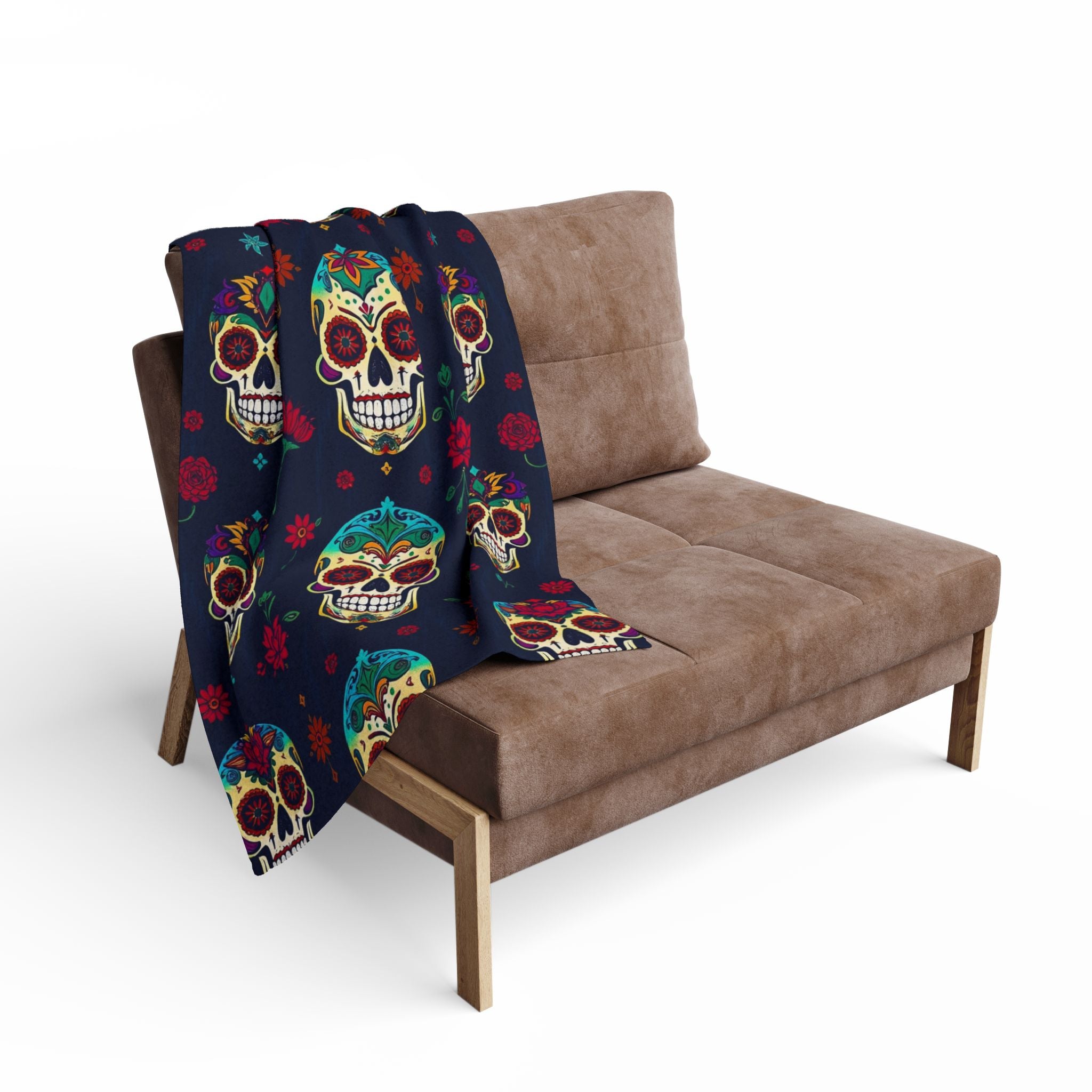 Colorful mexican sugar skull patterned fleece blanket draped over a brown sofa on a white background.