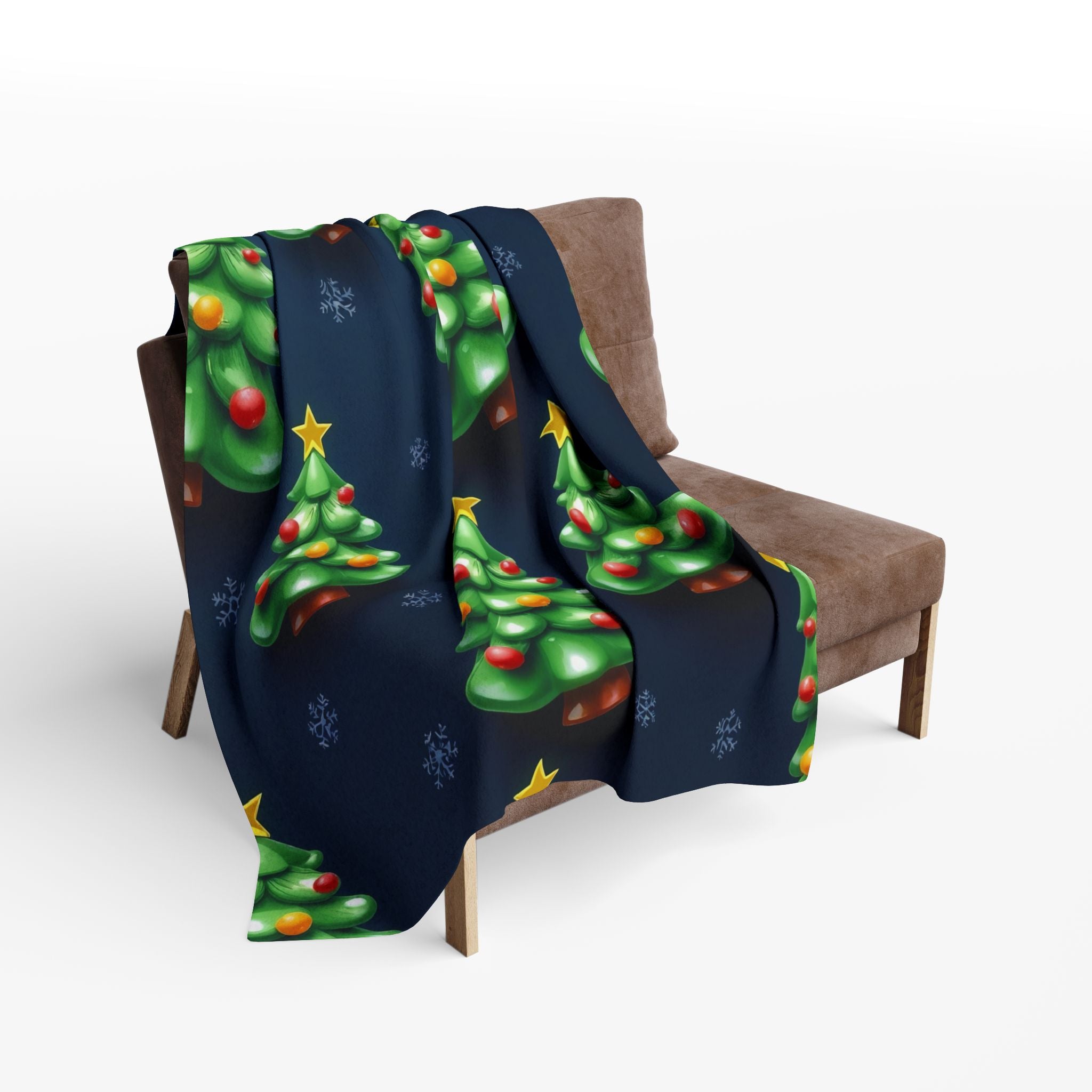 Blanket with Christmas tree design draped over a brown chair on a white background.