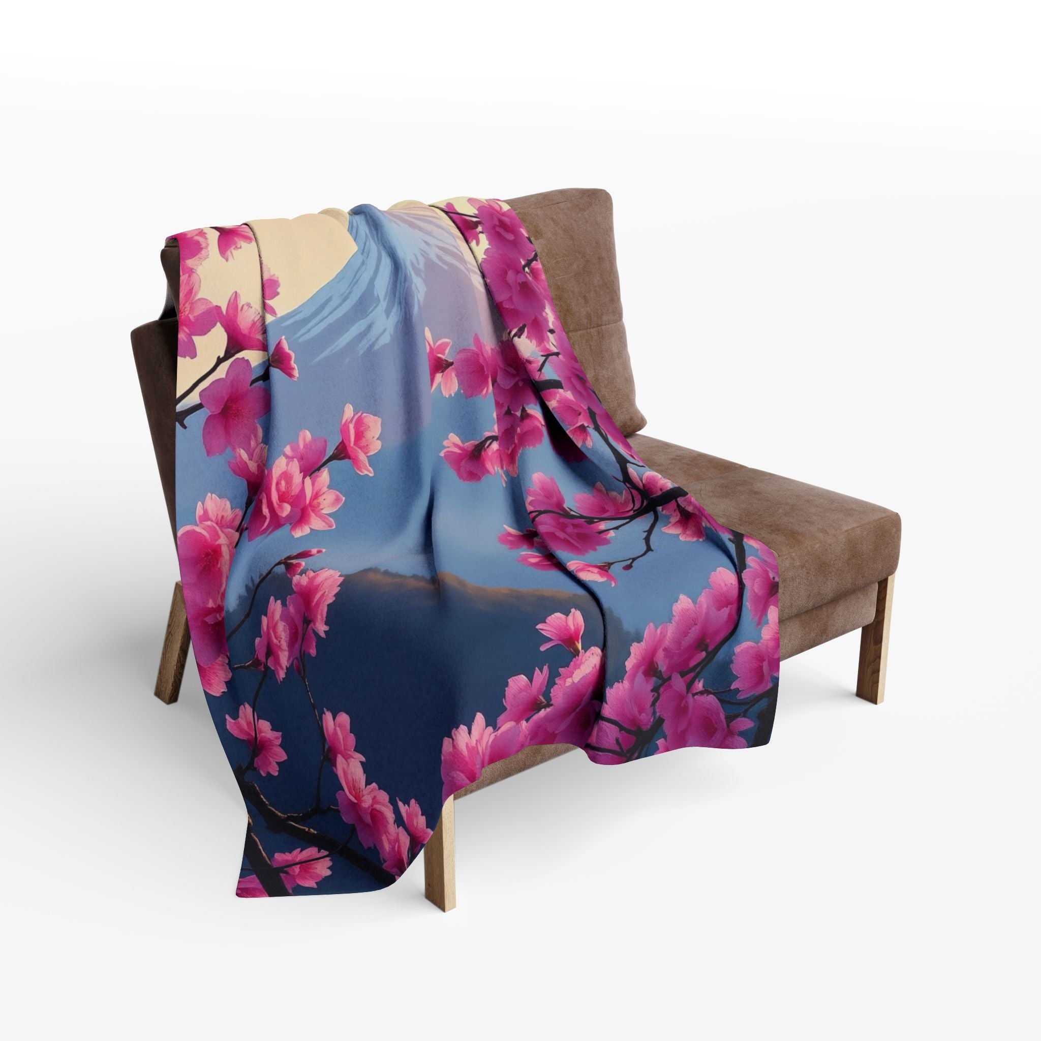 Pink cherry blossom floral patterned fleece blanket draped over a chair on a white background.