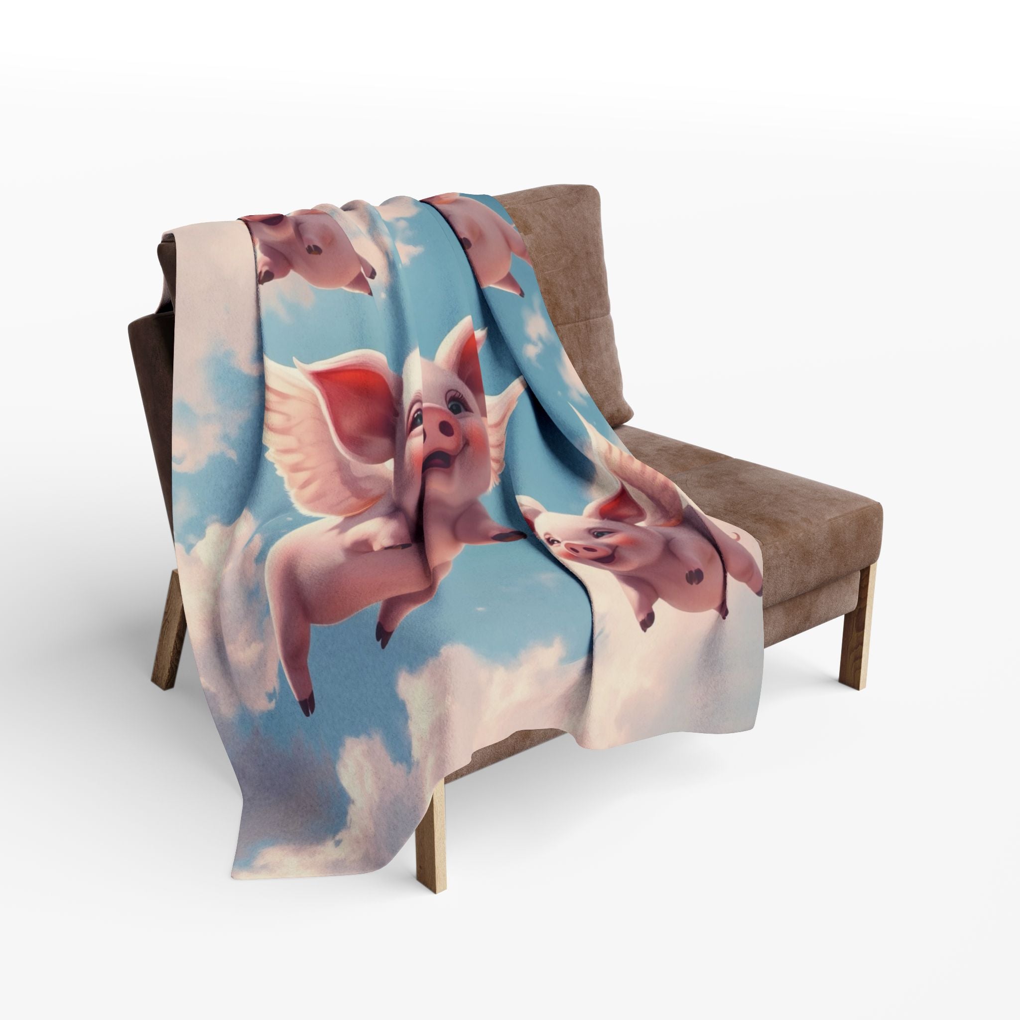 Blanket with cute flying pig design draped over a chair.