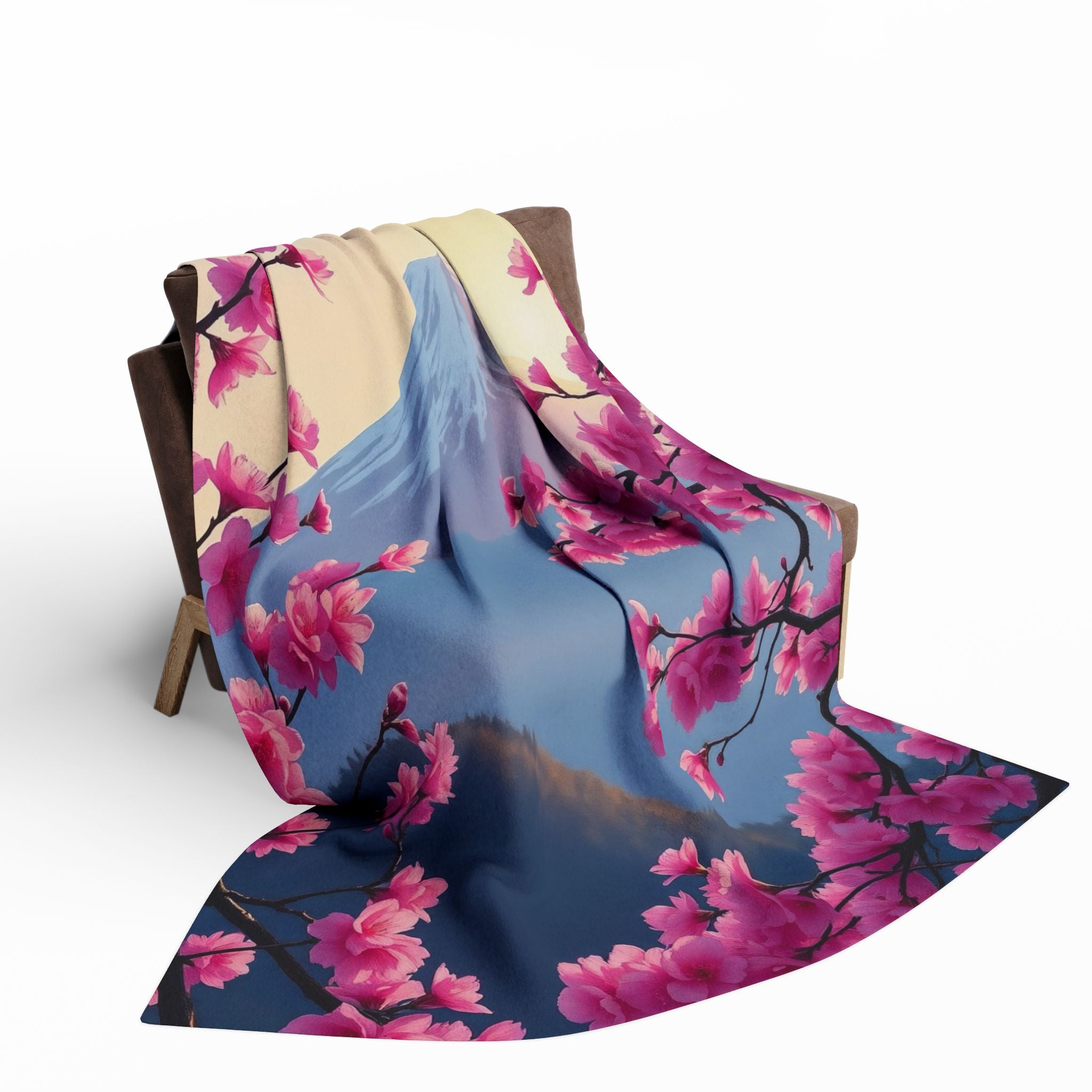 Pink cherry blossom floral pattern with mount fuji fleece blanket draped over a chair on a white background.