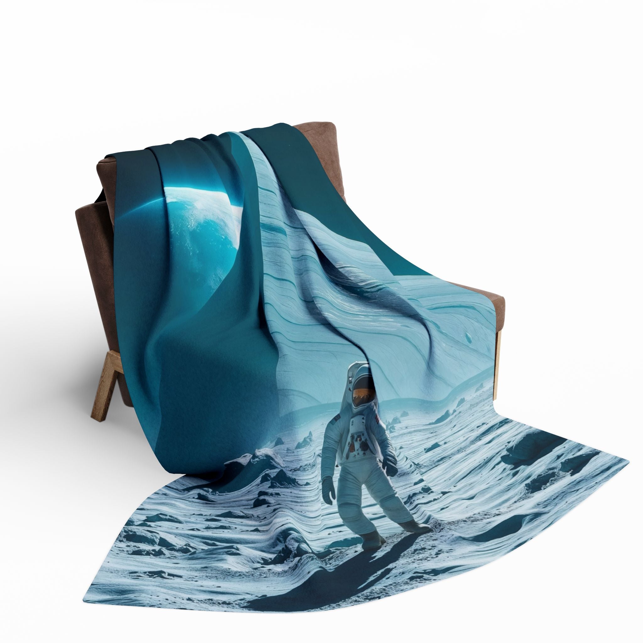 Folded blanket with an astronaut and huge pyramid on the moon design on a brown chair against a white background.