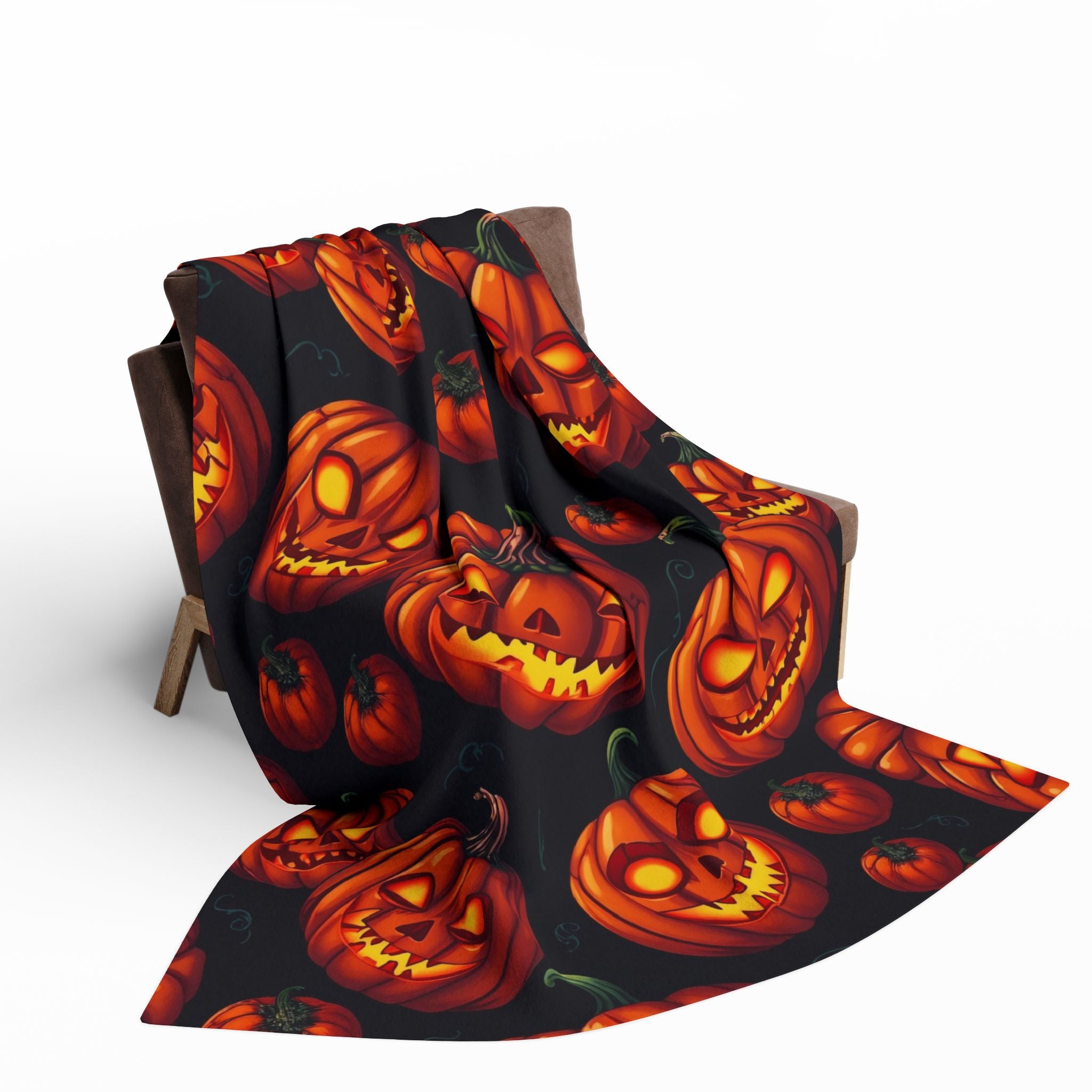 Halloween themed fleece blanket with scary pumpkin lanterns draped over a chair on a white background.