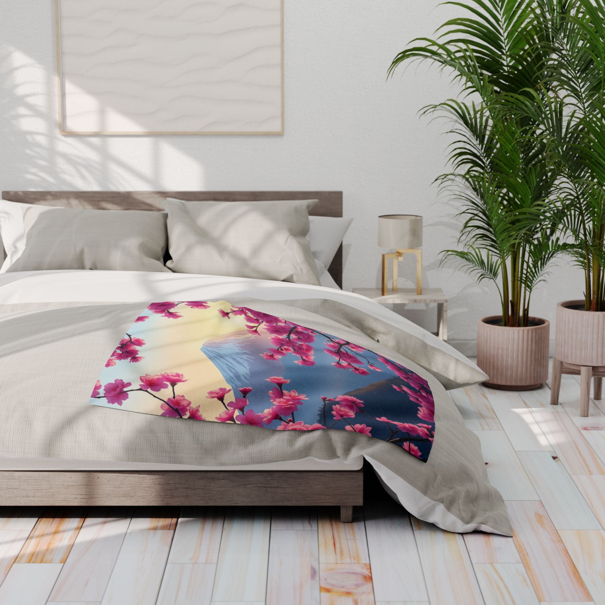 Bedroom with a bed featuring pink cherry blossom and mount fuji fleece blanket, nightstands, and plants.