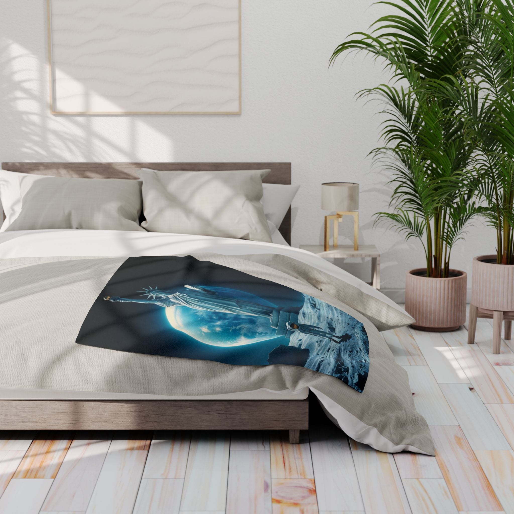 Bed with a decorative fleece blanket featuring the statue of liberty and an astronaut on the moon in a modern bedroom.