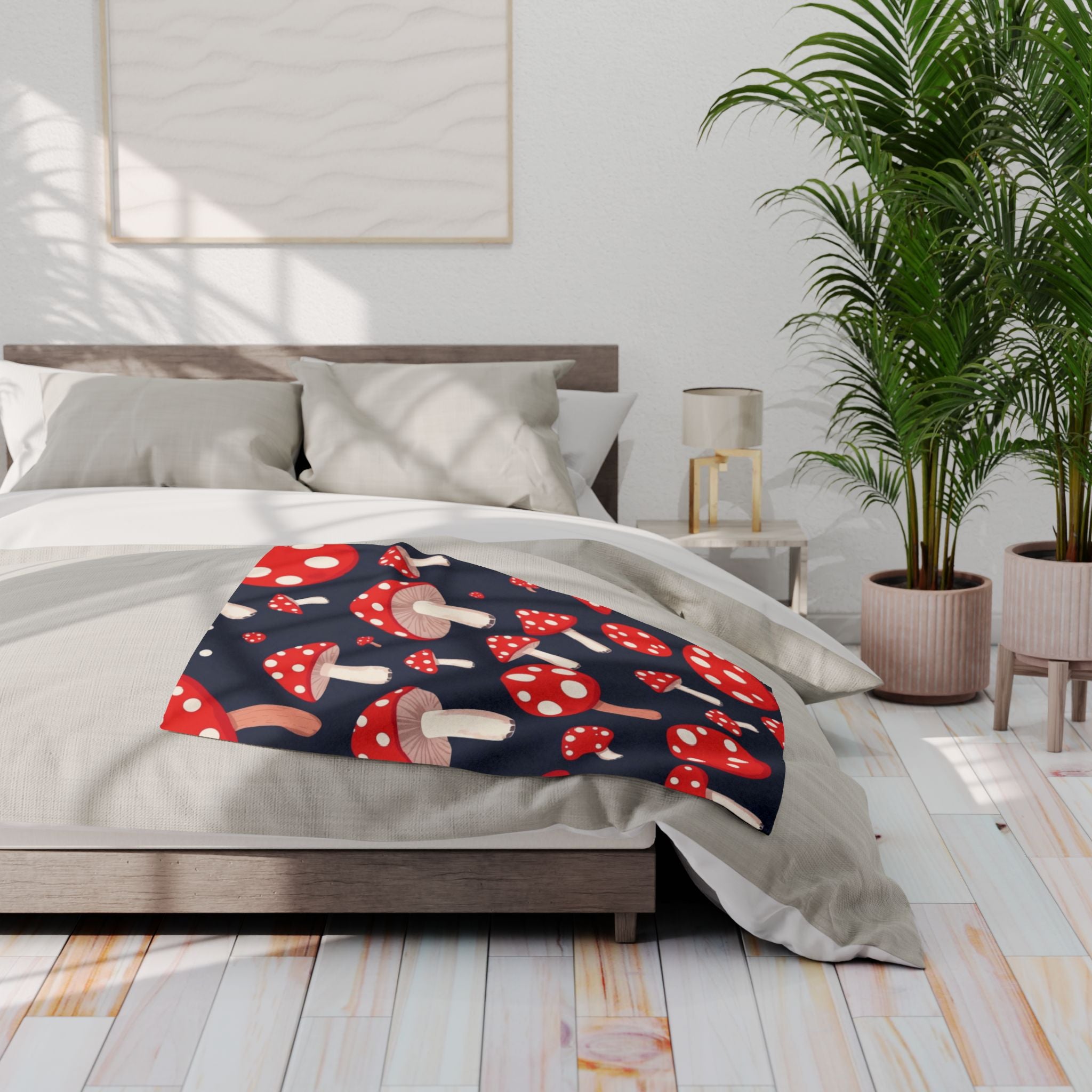 Bed with a red and white mushroom patterned fleece blanket in a bright bedroom setting.