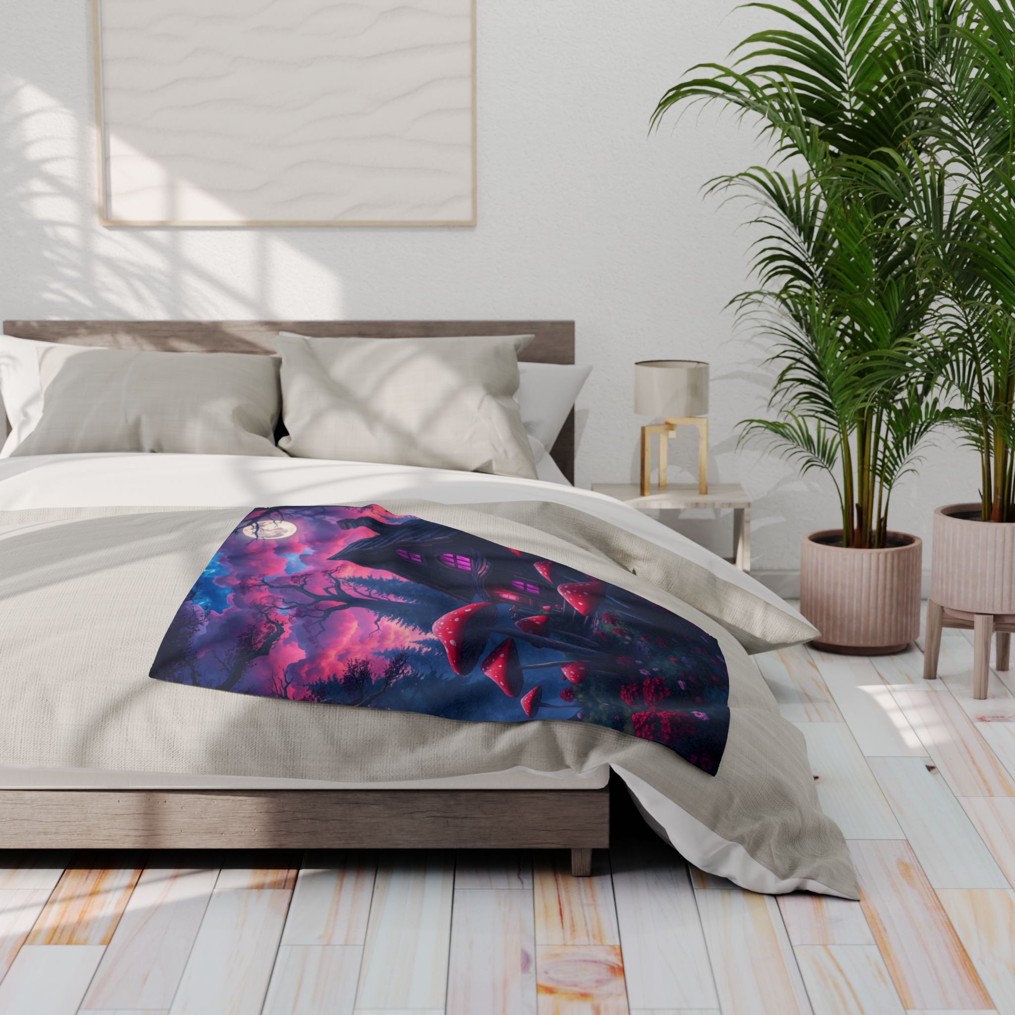 Bedroom with a colorful fleece blanket featuring a halloween haunted house and mushrooms on a bed, plants, and a lamp.
