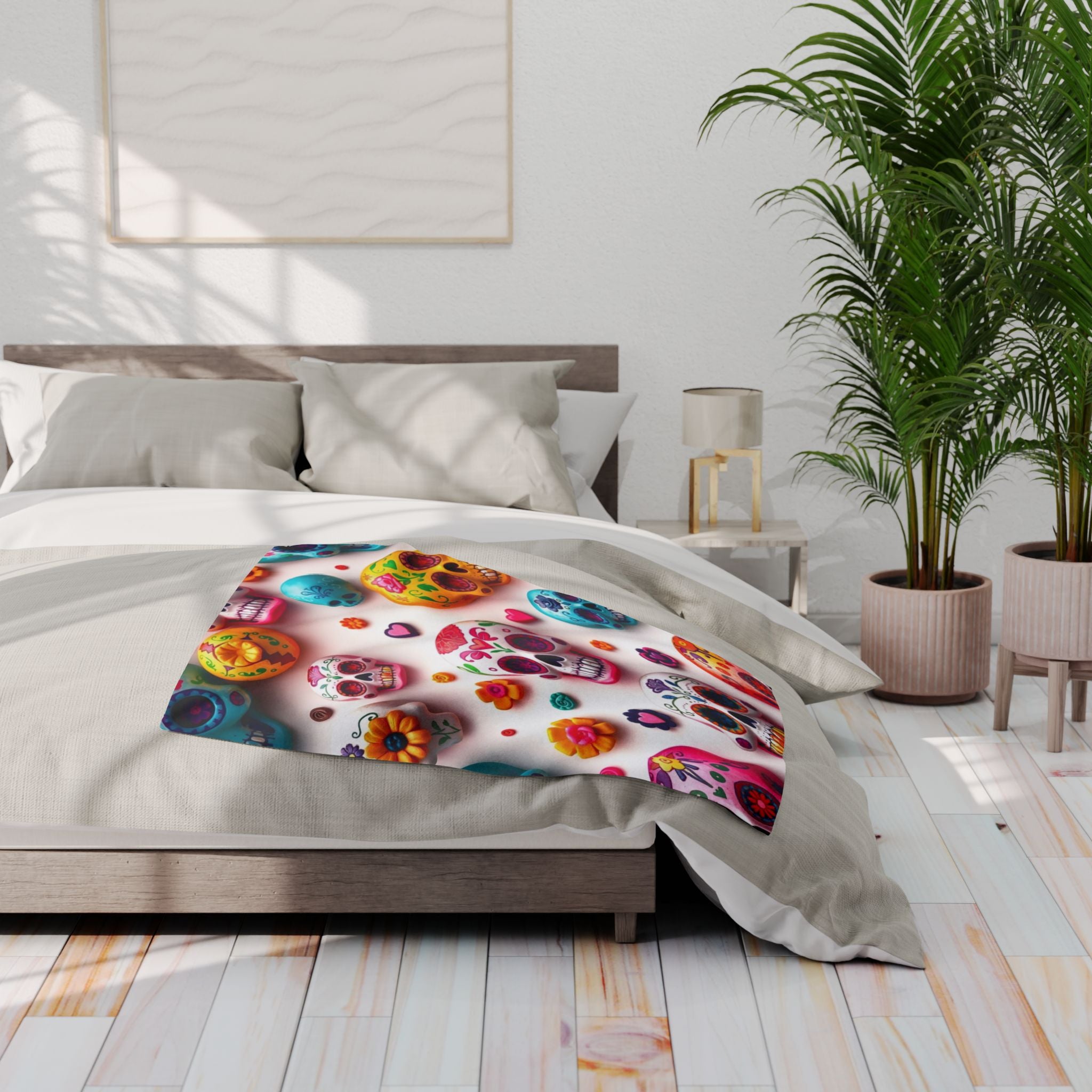 Bed with colorful floral patterned fleece blanket throw featuring mexican day of the dead sugar skulls in a bright bedroom.