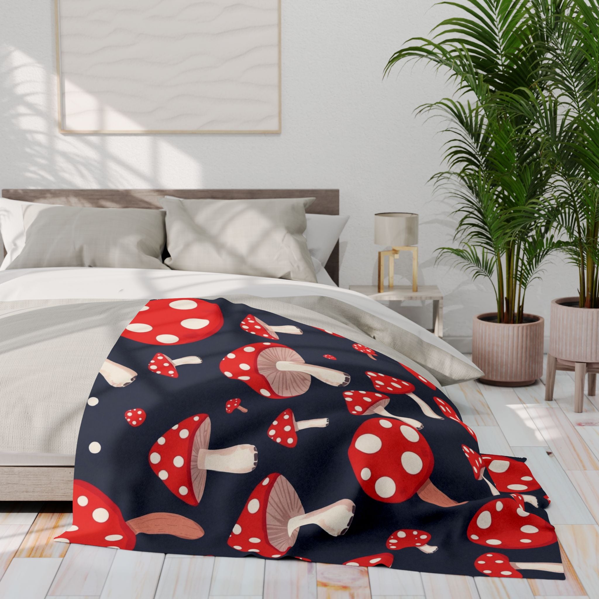 Red and white mushroom patterned fleece blanket on a bed in a bright bedroom with plants and decor.