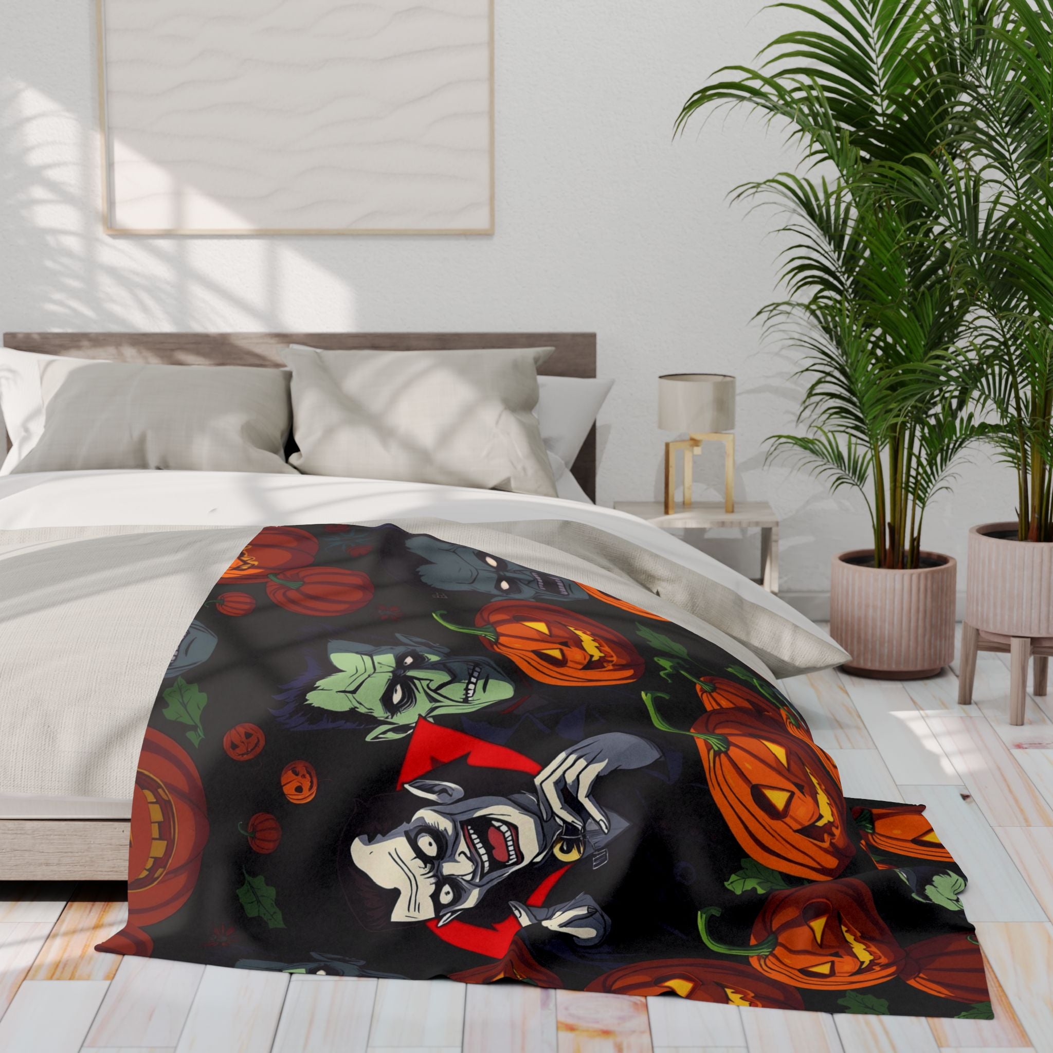 Halloween themed fleece blanket featuring Dracula, Frankenstein and pumpkin lanterns draped over a bed in a bedroom setting.