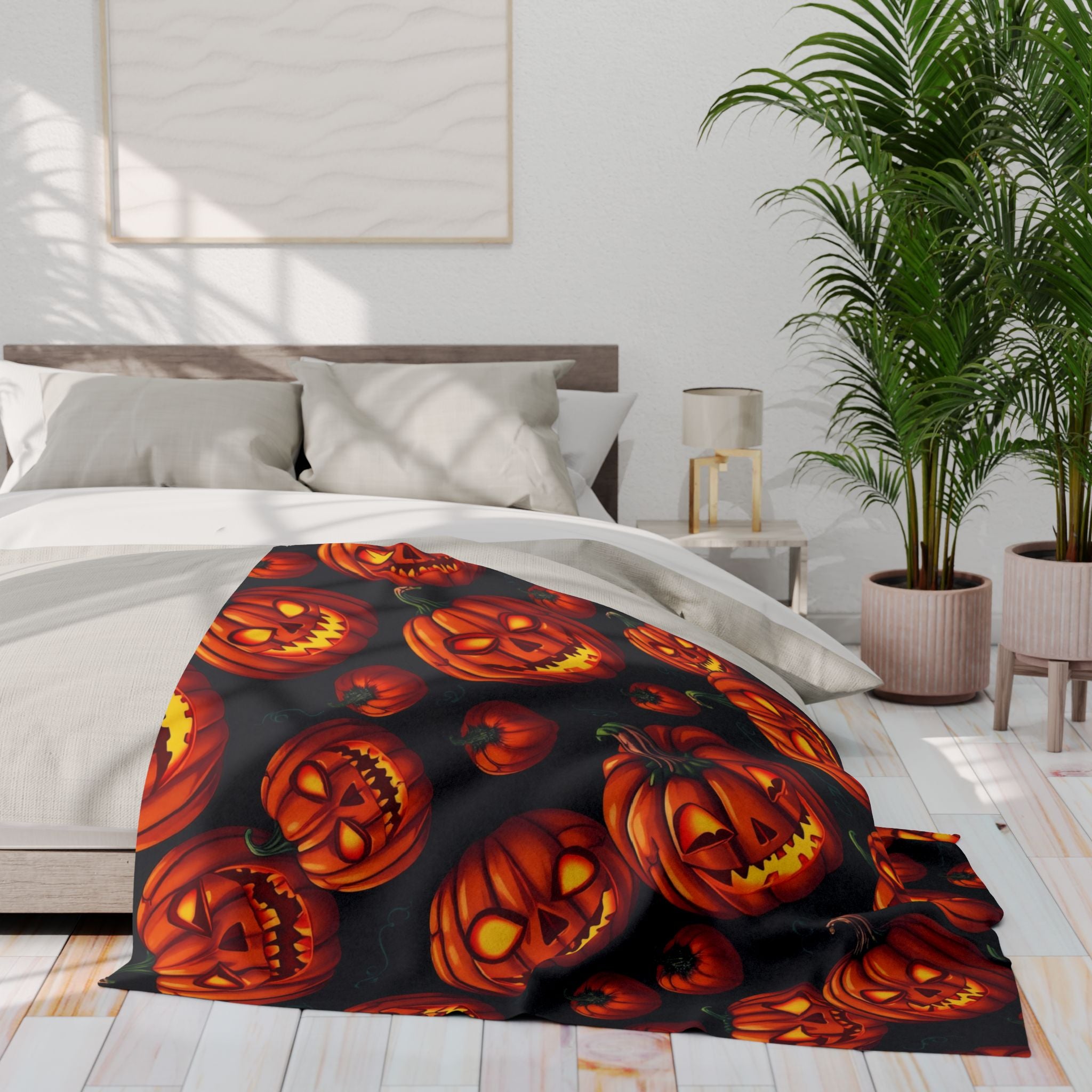 Bed with a Halloween themed spooky pumpkin fleece blanket in a bedroom setting.