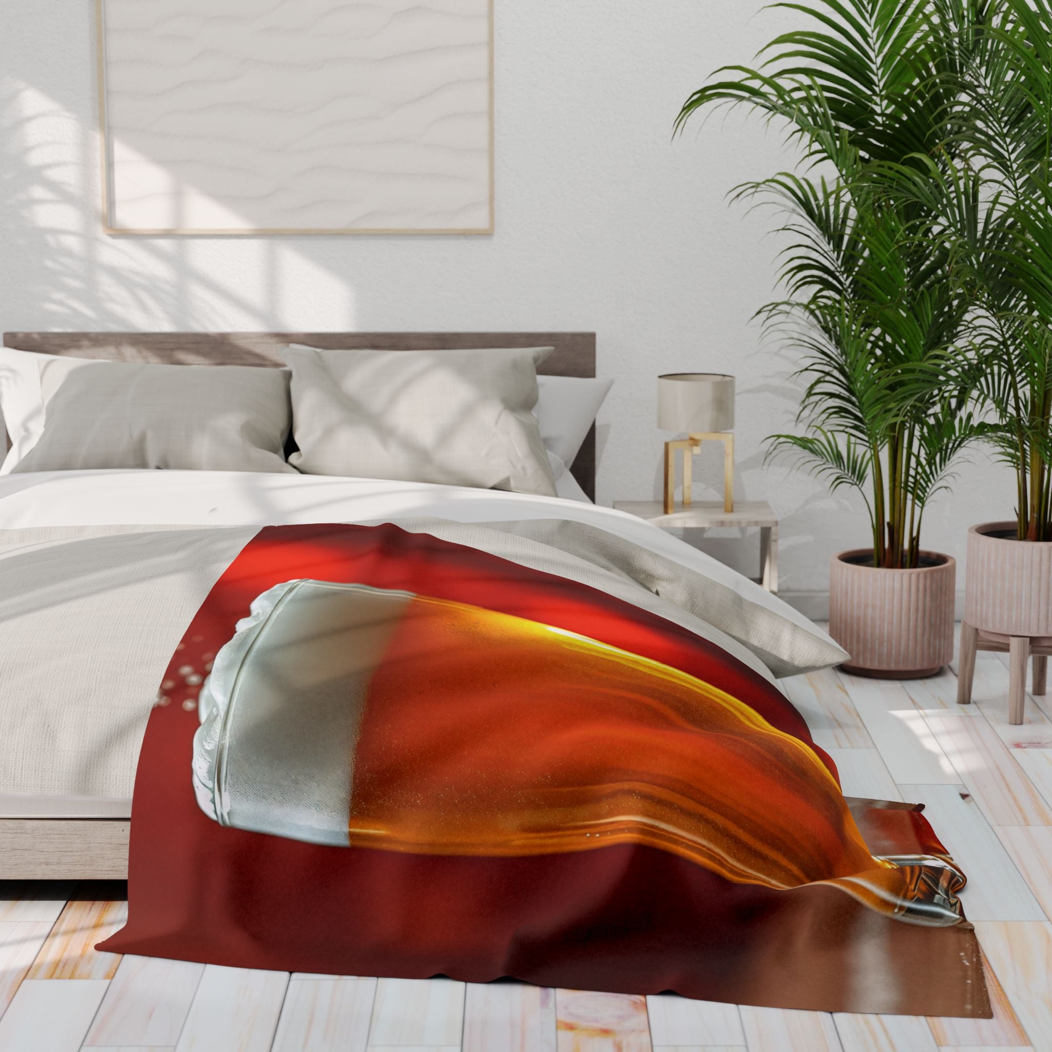 Blanket of a pint of lager draped over a bed in a bright bedroom with plants and a lamp.