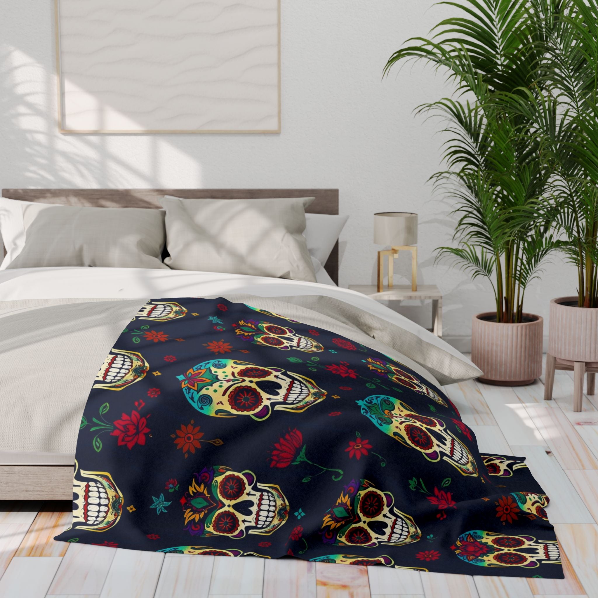 Colorful mexican dead of the dead sugar skull patterned blanket on a bed in a bright bedroom with plants and a lamp.