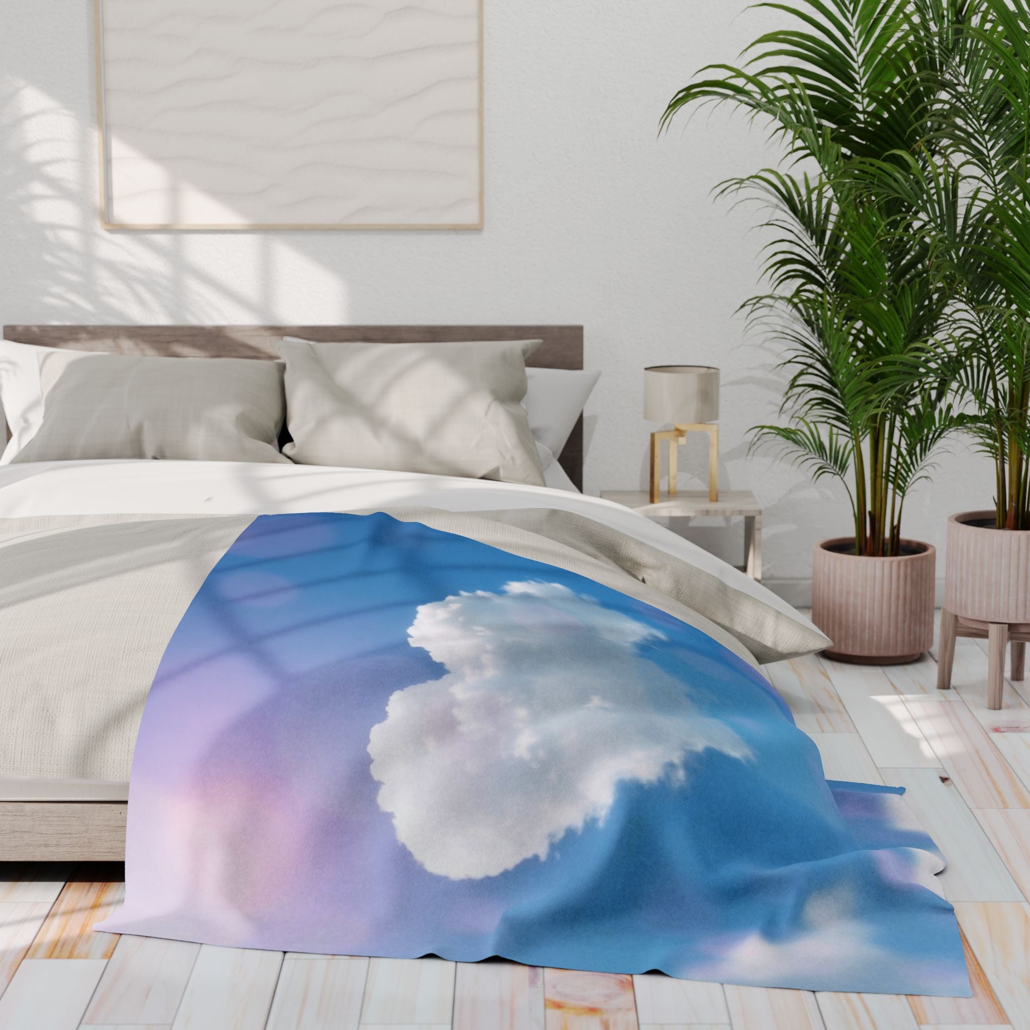 Bed with a white heart cloud on a blue sky fleece blanket in a bright bedroom setting.