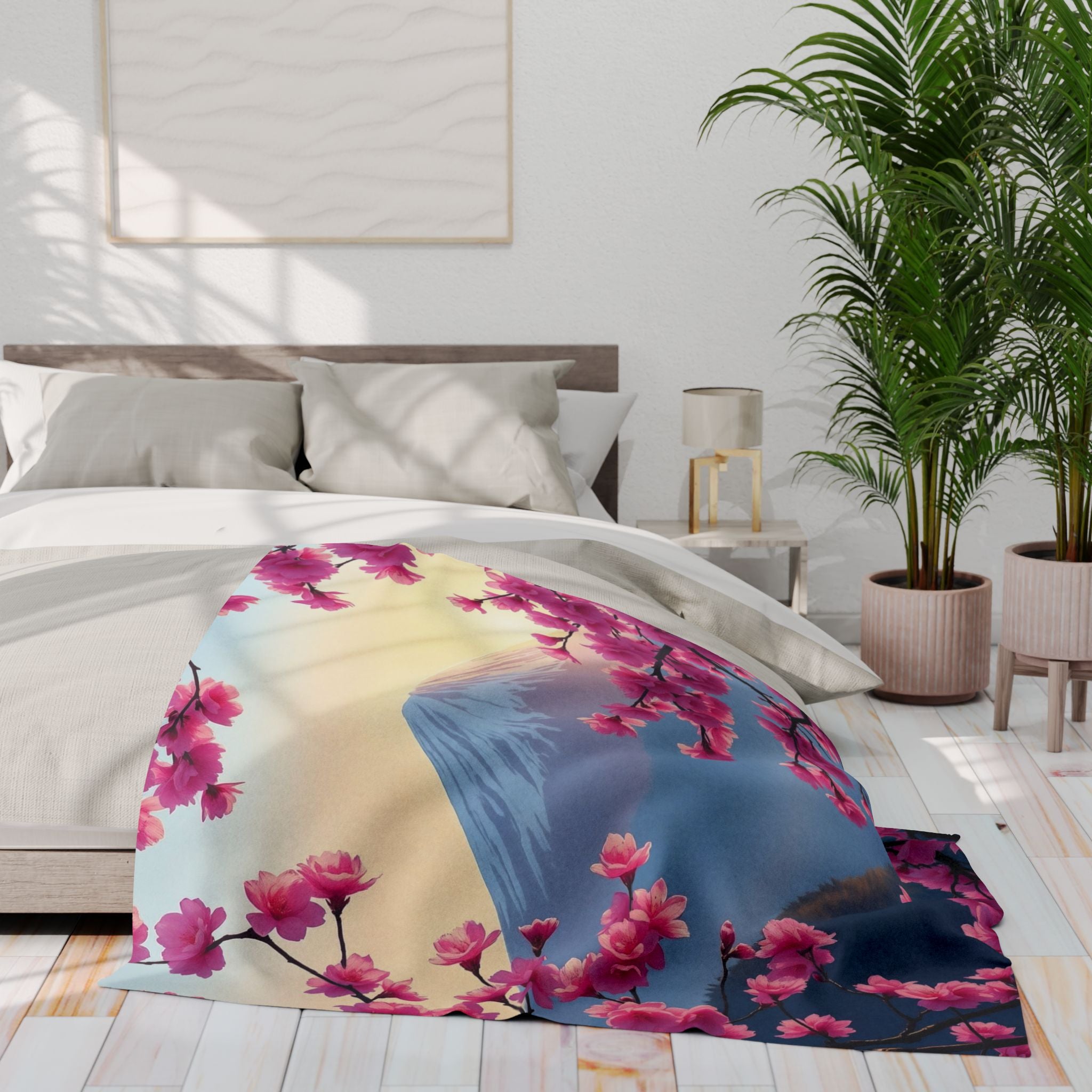 Bed with a pink cherry blossom and mount fuji fleece blanket in a bright bedroom setting.