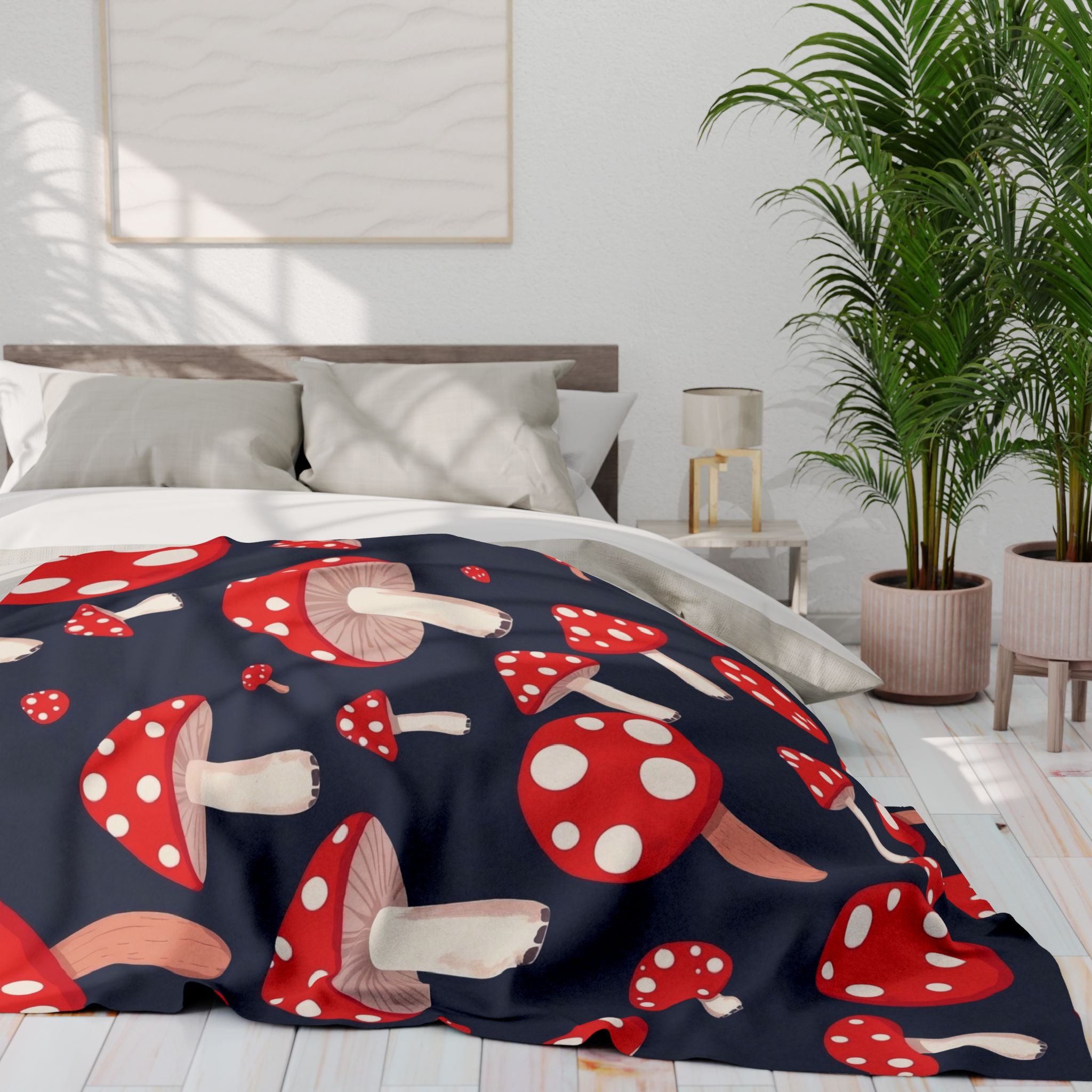 Bed with a red and white mushroom patterned fleece blanket in a bright bedroom.