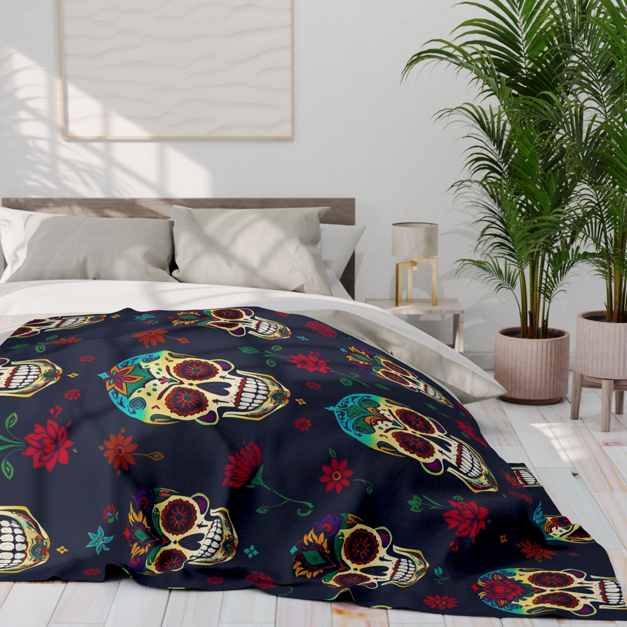 Colorful mexican day of the dead sugar skull patterned fleece blanket throw on a bed in a bedroom with plants and a lamp.