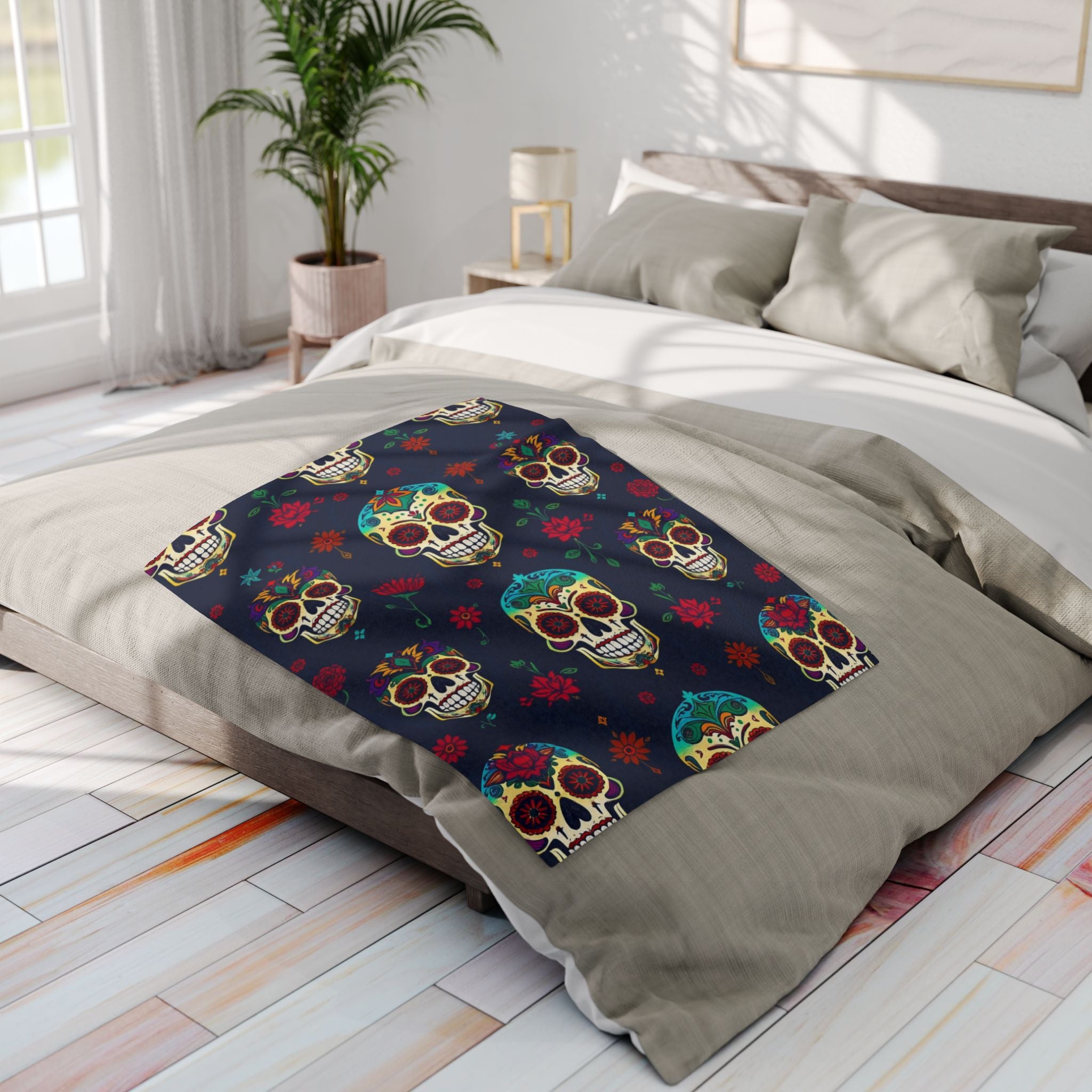 Decorative blanket with colorful mexican day of the dead sugar skull pattern on a bed in a bright bedroom.