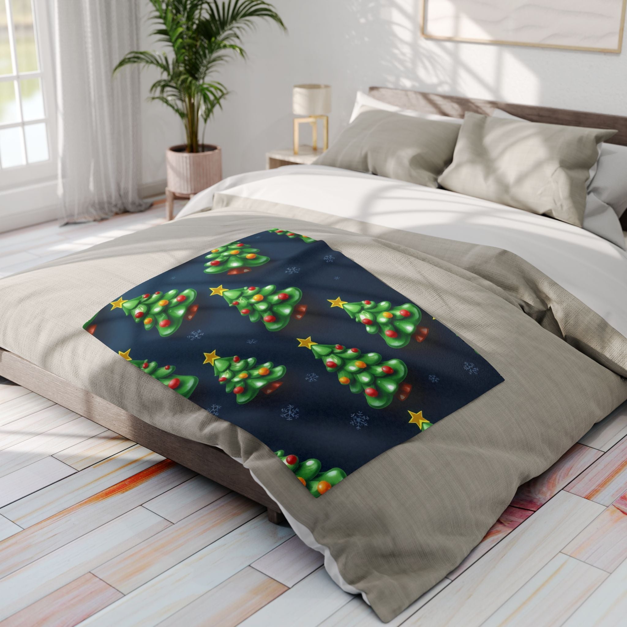Fleece blanket with Christmas tree design on a bed in a bright bedroom.