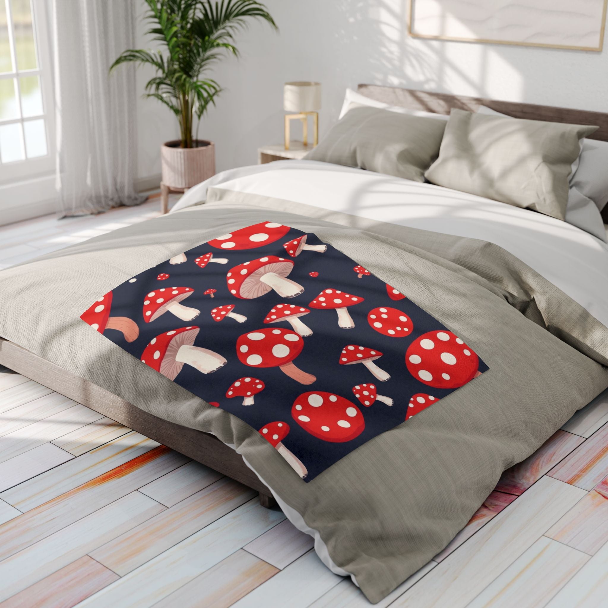 Bed with a red and white spotted mushroom patterned throw blanket in a bright bedroom.
