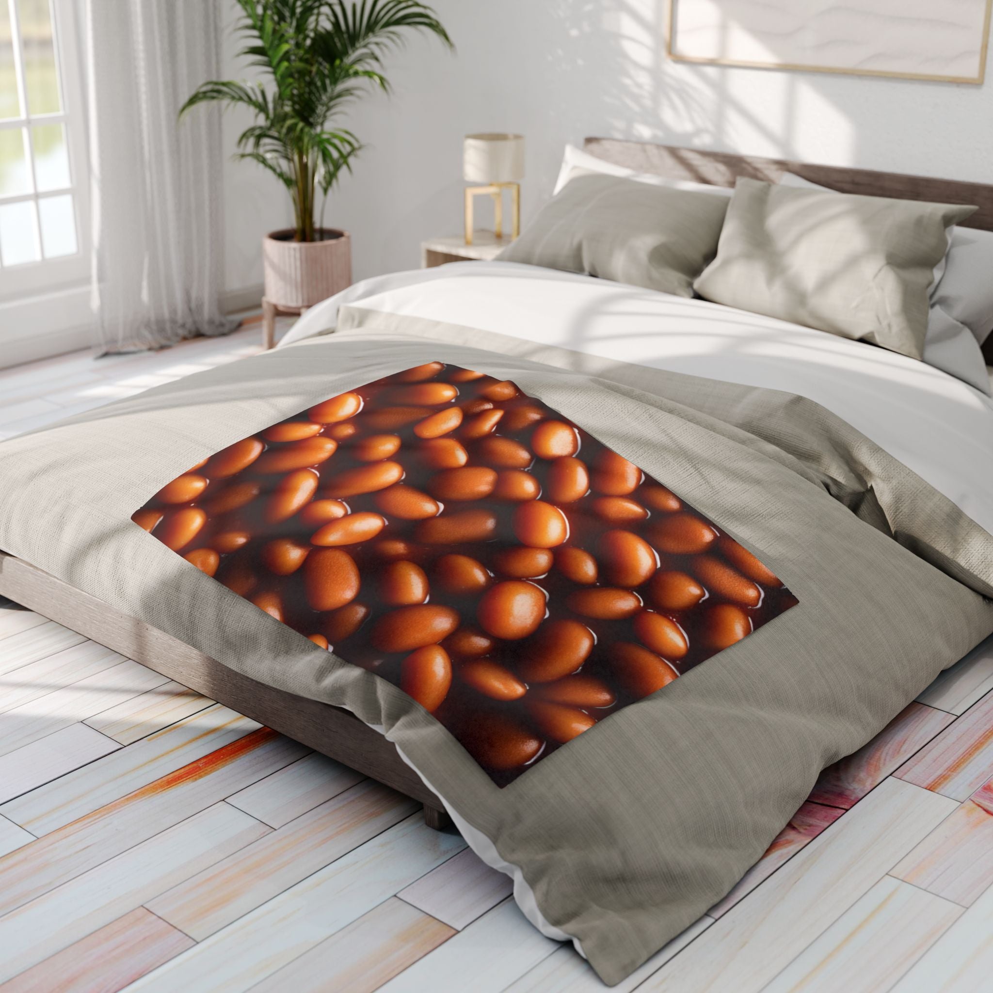 Fleece blanket with a design of baked beans on a bed in a bright bedroom.