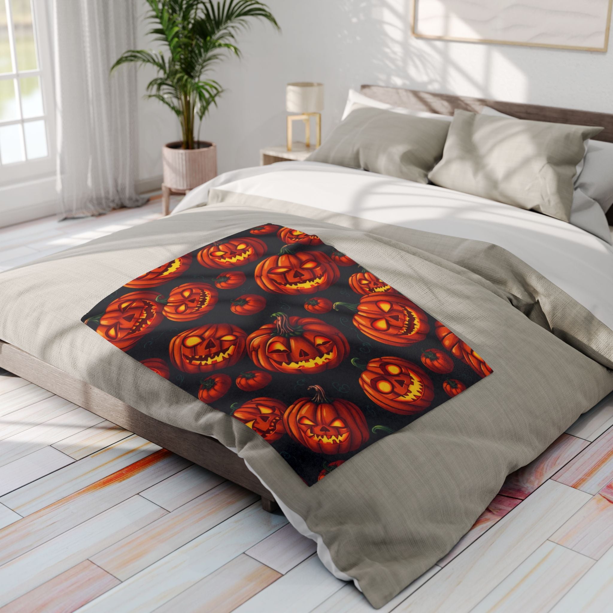 Bed with Halloween-themed pumpkin lanterns fleece blanket in a bright bedroom.