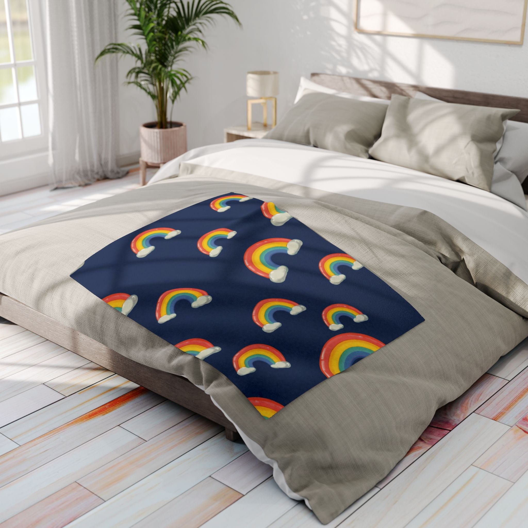 Bed with rainbow-patterned fleece blanket in a bright bedrooom.