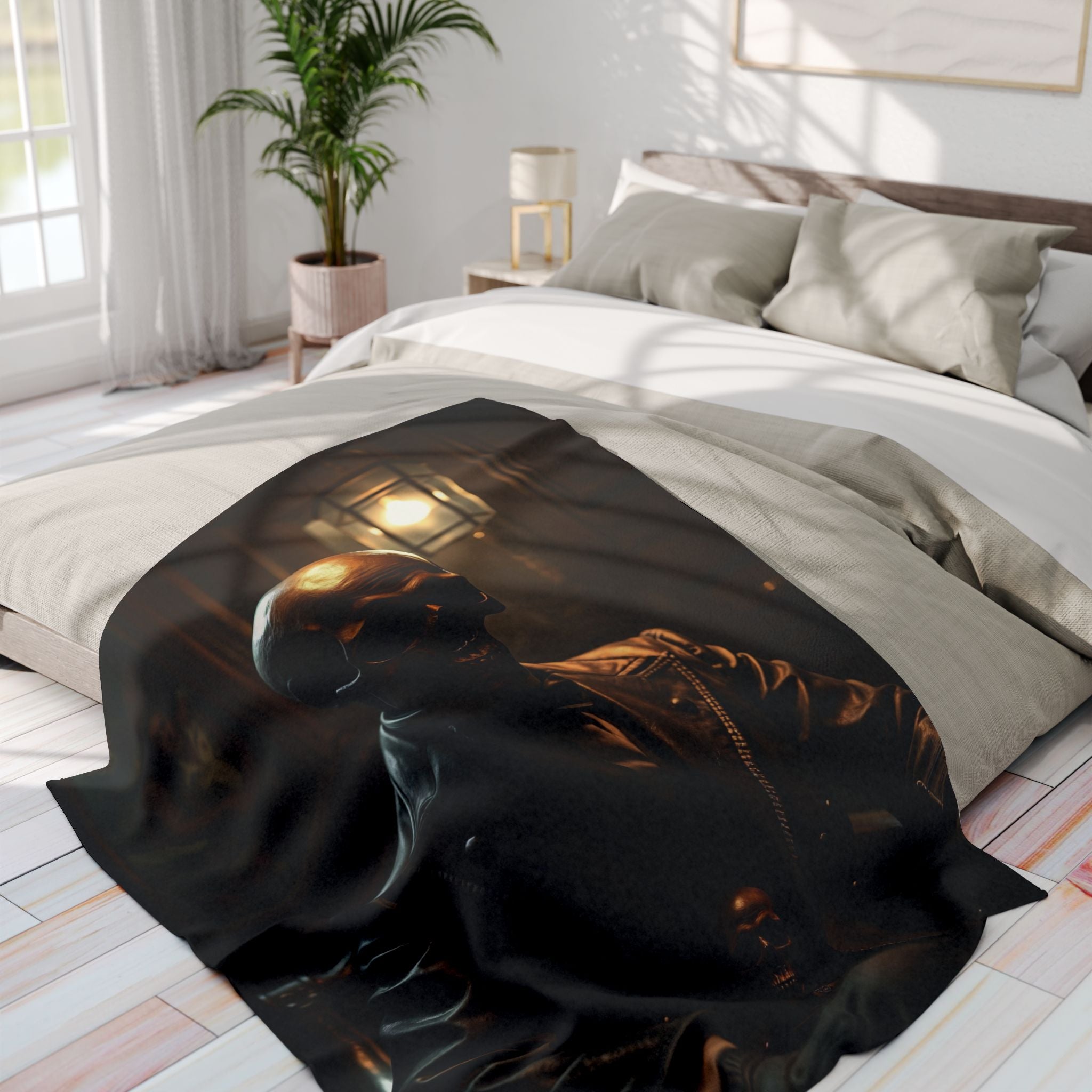 Black fleece blanket with a gothic skull design draped over a bed in a bright bedroom.