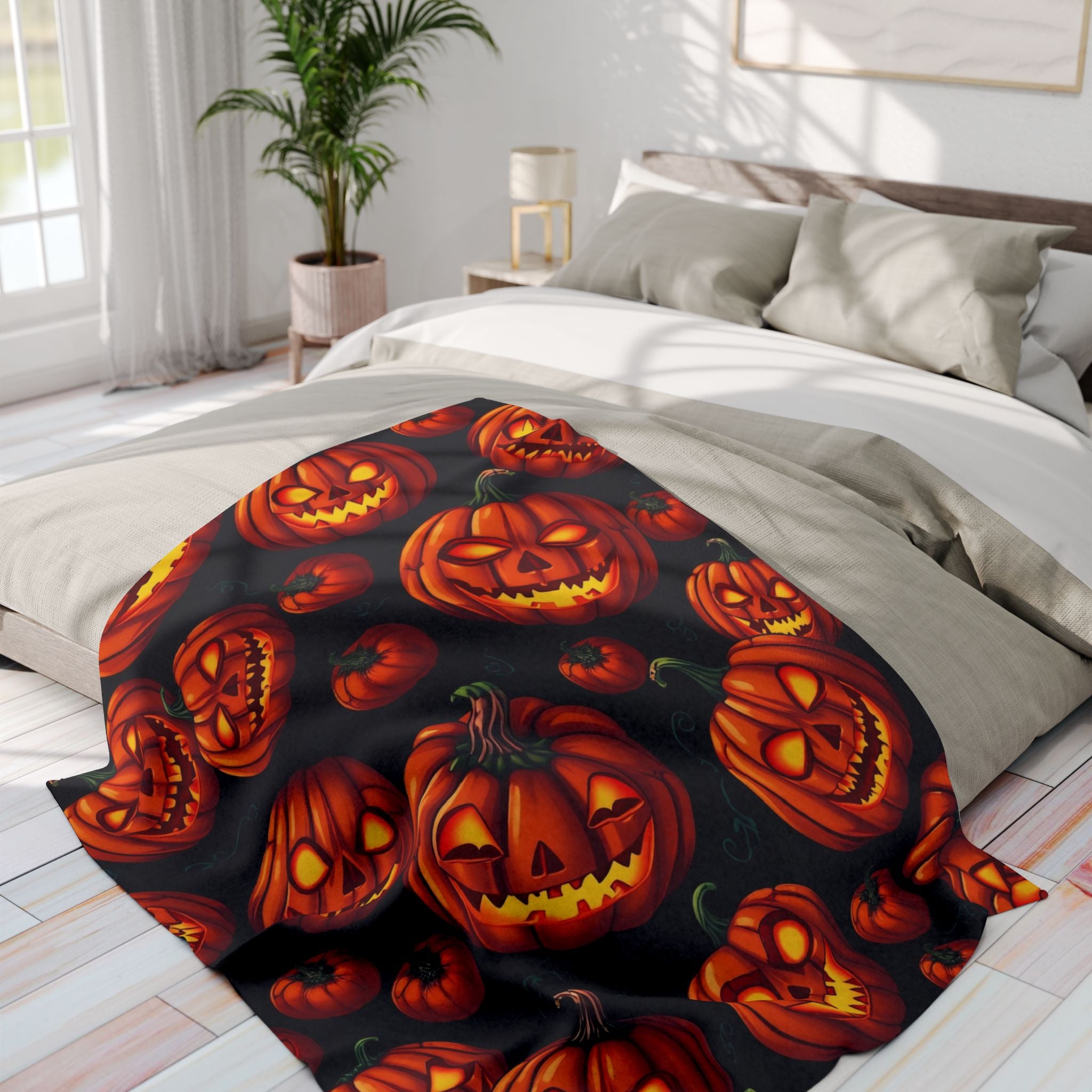 Halloween-themed blanket with pumpkin lanterns on a bed in a bright bedroom.