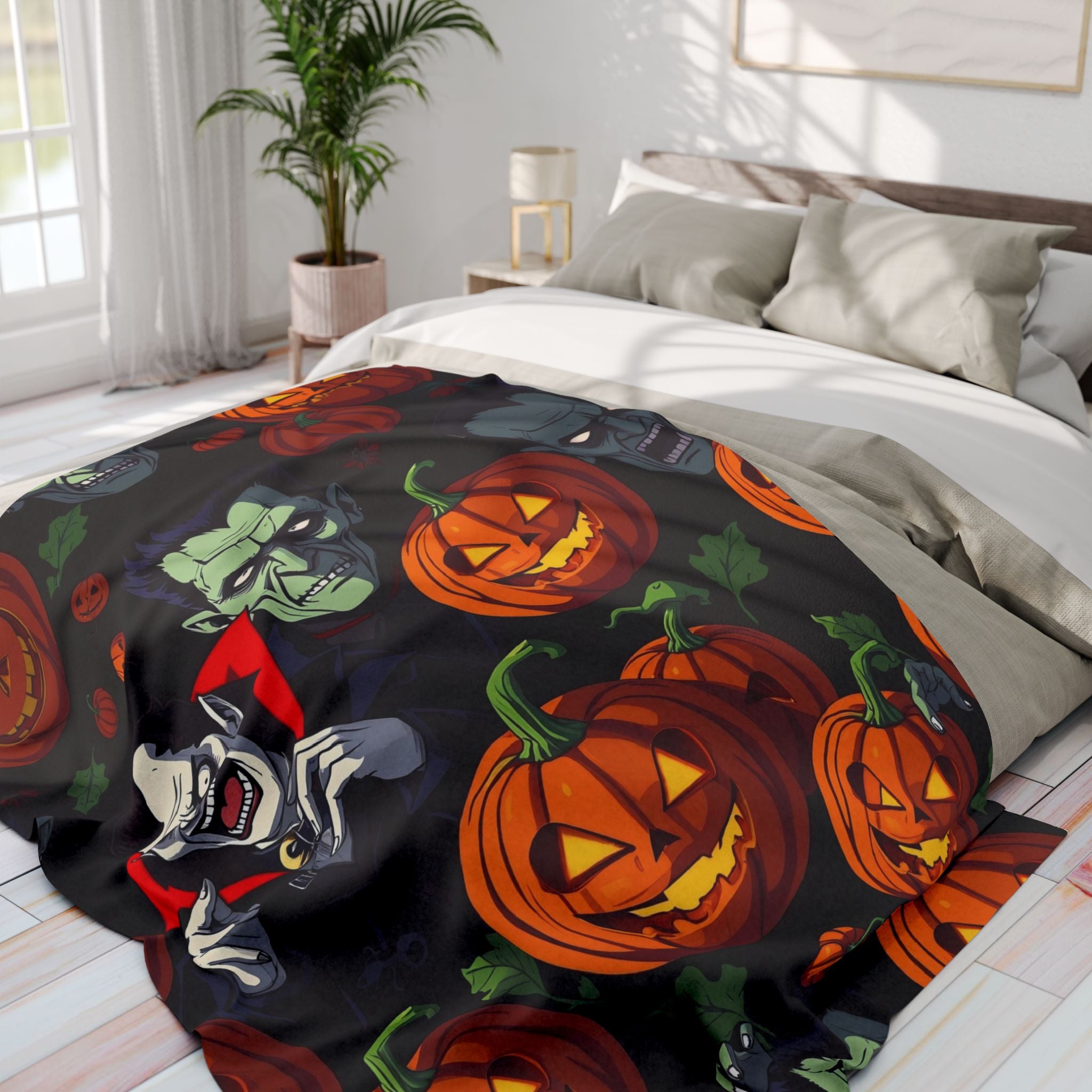 Halloween themed fleece blanket with Dracula, Frankenstein, pumpkin lanterns and ghosts on a bed in a bedroom.