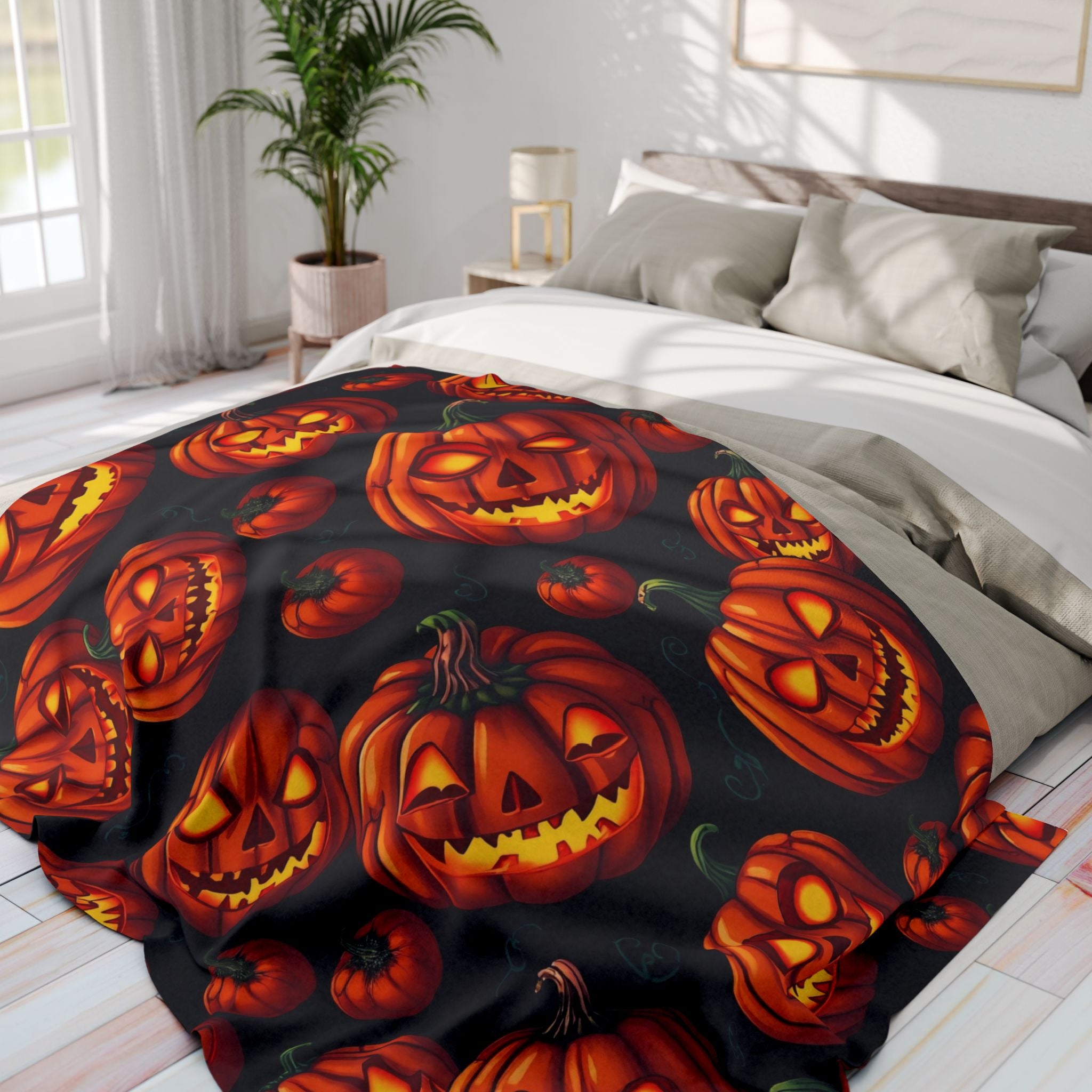Halloween-themed blanket with pumpkin lanterns on a bed in a bedroom.