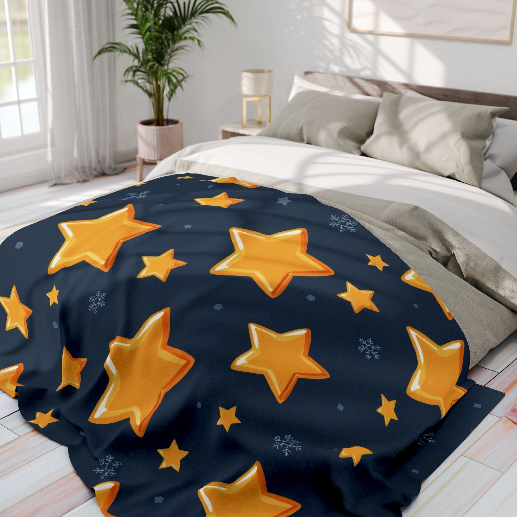 Navy blanket with gold stars on a bed in a bright bedroom.