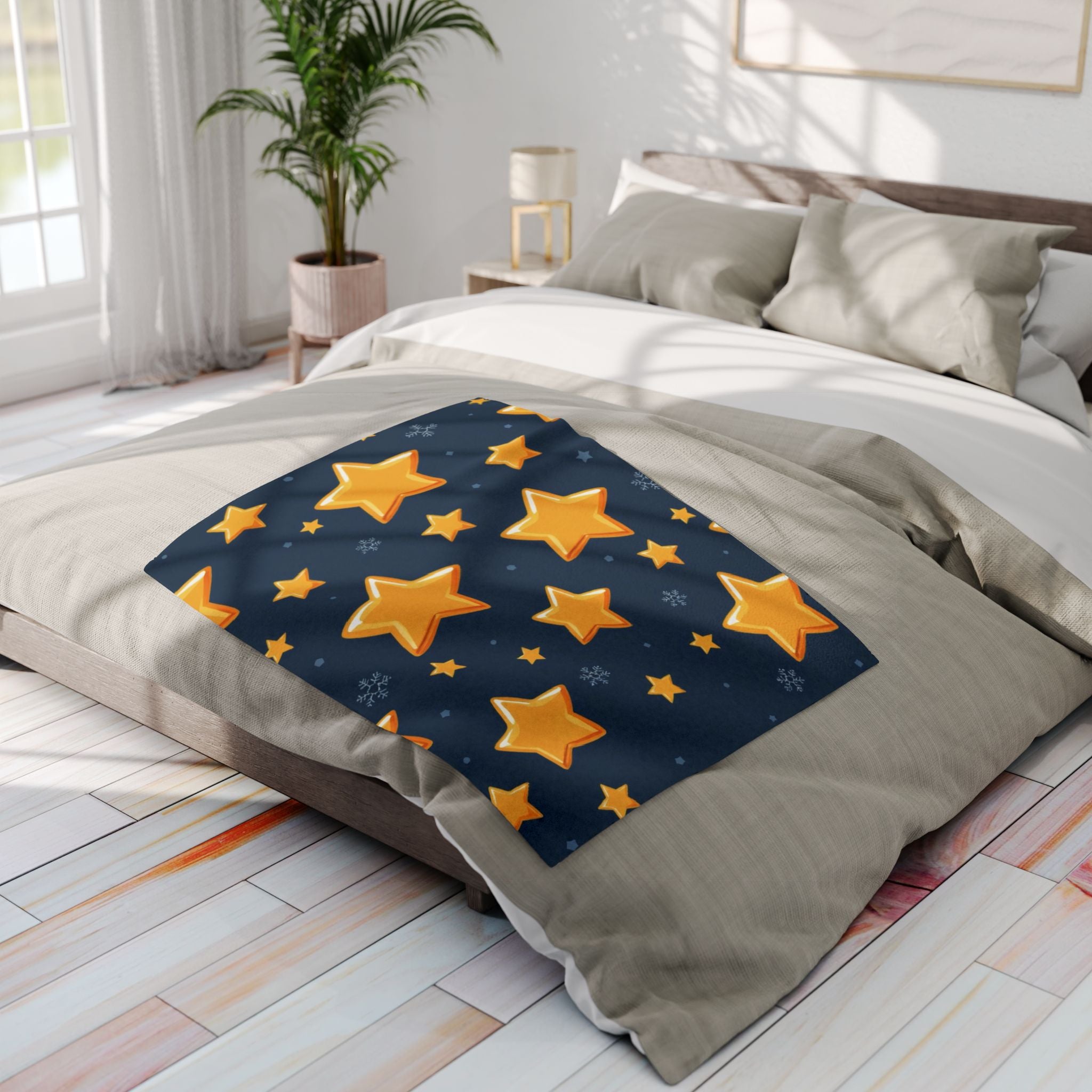 Gold star-patterned blanket on a bed in a bright bedroom.