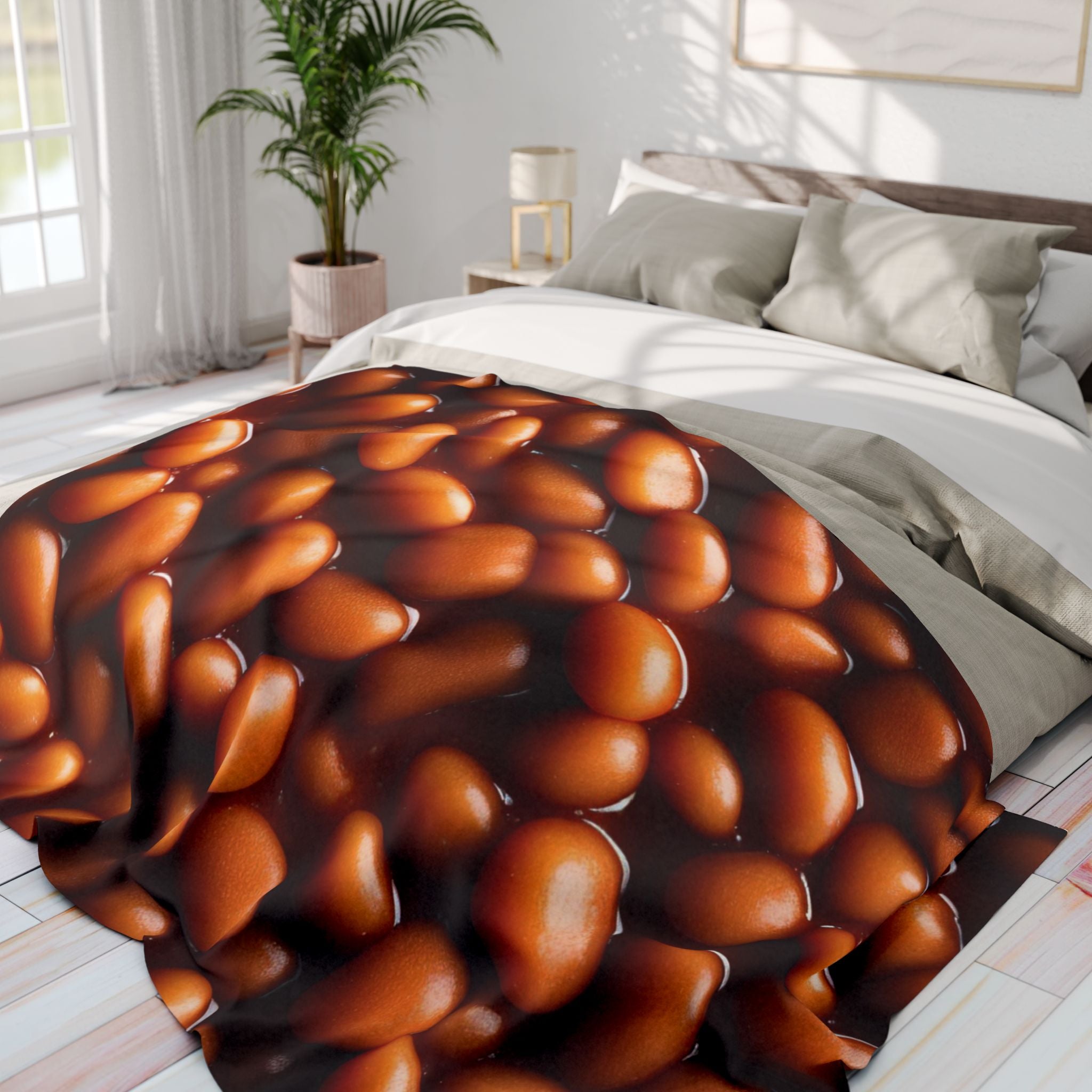 Printed fleece blanket with a baked bean like pattern on a bed in a bedroom setting.
